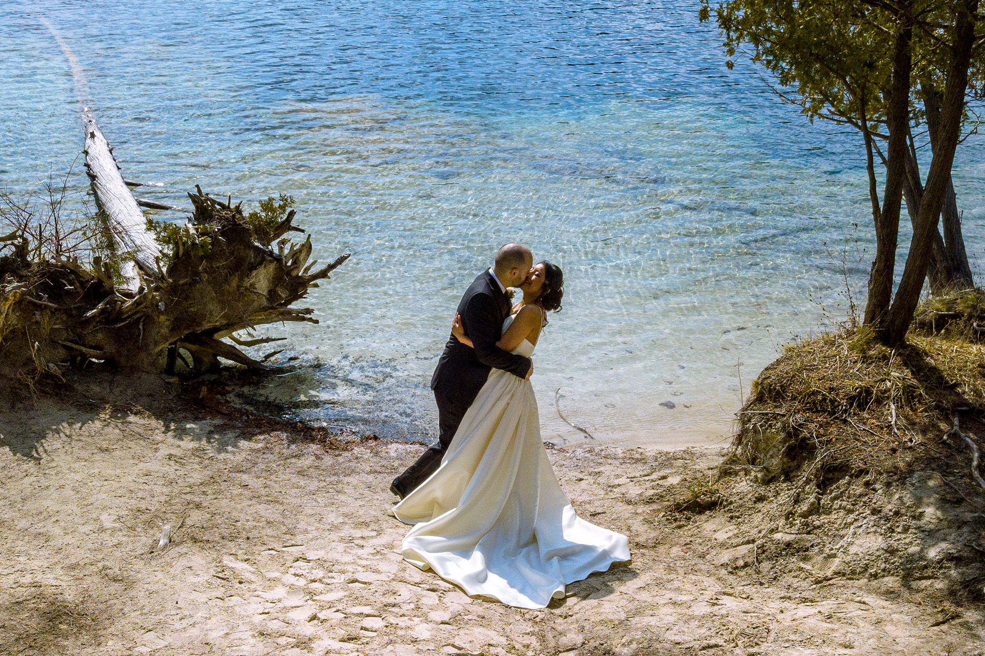 Groom kissing bride lake side
