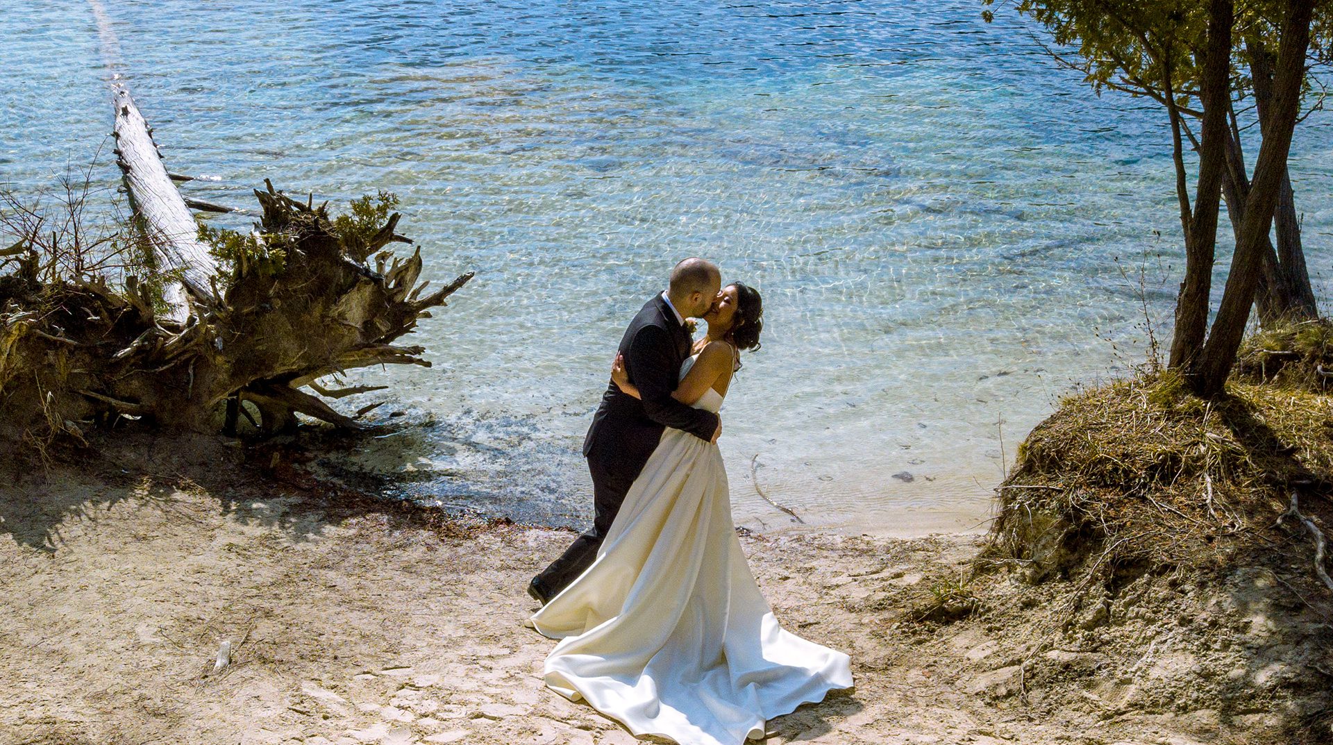 Groom kissing bride lake side